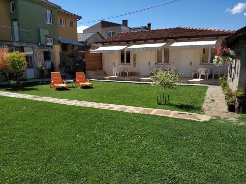 une cour avec des chaises longues et une maison avec une terrasse dans l'établissement Apartments Three Ohrid, à Ohrid