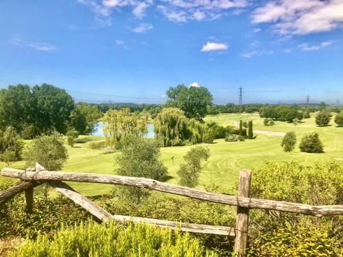 a wooden fence in front of a golf course at Creative Design House Golf & SPA in Pozzolengo