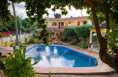 a swimming pool in front of a house at São Pedro Guesthouse in São Tomé