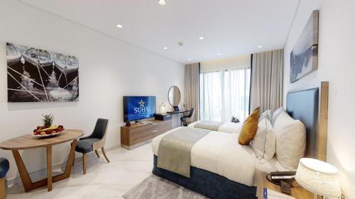 a hotel room with a bed and a desk and a table at SUHA Mina Rashid Hotel Apartments in Dubai