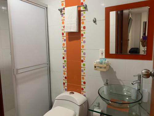 a bathroom with a toilet and a glass sink at Hermoso apartamento con parqueadero in Fusagasuga