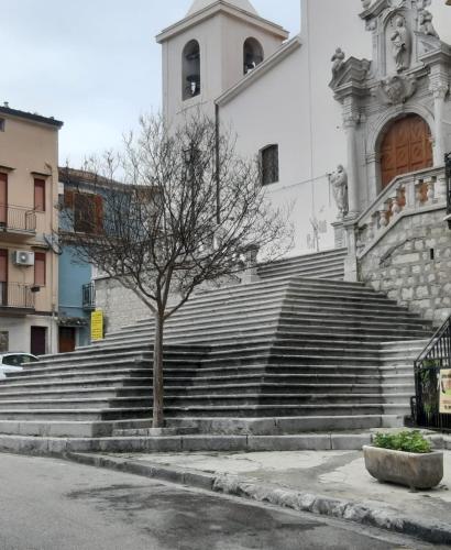 a group of stairs in front of a building with a tree at GUEST HOUSE PIANA DEGLI ALBANESI in Piana degli Albanesi