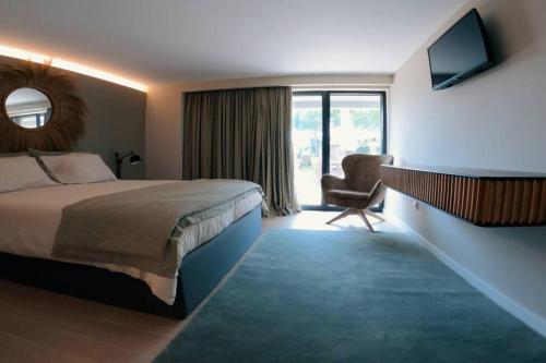 a hotel room with a bed and a chair at Casa da fonte in Apúlia