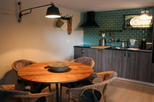 a kitchen with a wooden table and some chairs at Casa da fonte in Apúlia