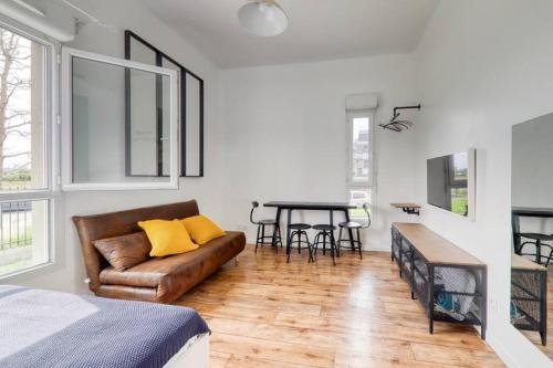 un salon avec un canapé et une table dans l'établissement Studio Art - Shopping center and train station 500m - Disneyland Paris 5min, à Montévrain