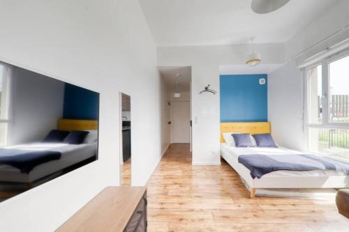 Duas camas num quarto com paredes azuis e brancas em Studio Art - Shopping center and train station 500m - Disneyland Paris 5min em Montévrain