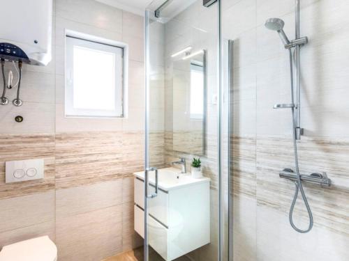 łazienka z przeszkloną kabiną prysznicową i umywalką w obiekcie APARTMENT GLORIA Blue 1 w mieście Malinska