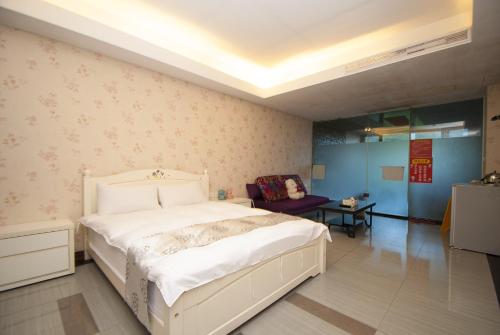 a bedroom with a white bed in a room at 礁溪景觀溫泉會館 in Jiaoxi