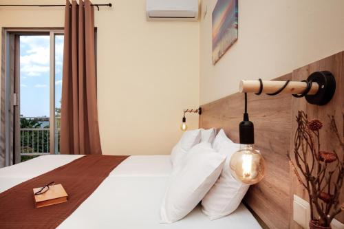 a bedroom with a bed with white pillows and a lamp at Aurora in Potos