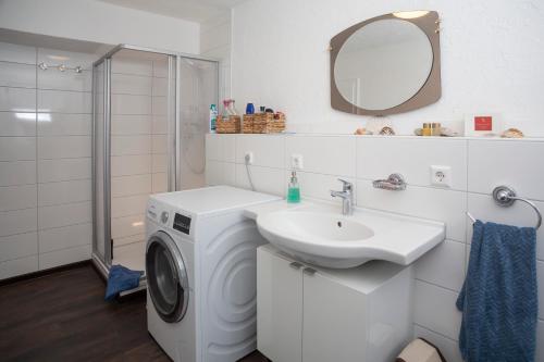a white bathroom with a washing machine and a sink at Ferienwohnung Alt Einbeck in Einbeck