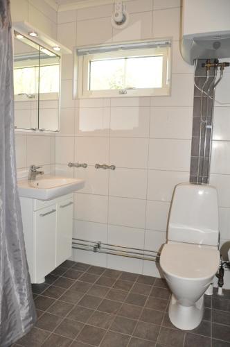 uma casa de banho com um WC e um lavatório em Grankullavik Fritidsby em Byxelkrok