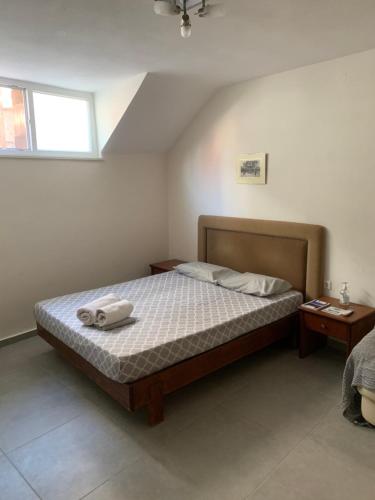 een slaapkamer met een bed met twee handdoeken erop bij Centrally Located Private Rooms in Heraklion