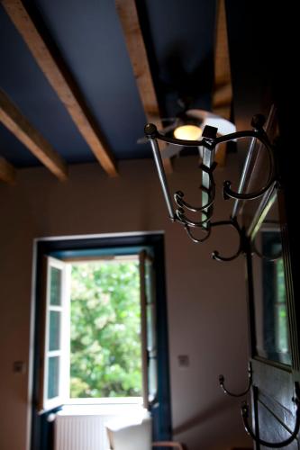 a chandelier hanging from a ceiling with a window at l'Ancre Vive in Charentay