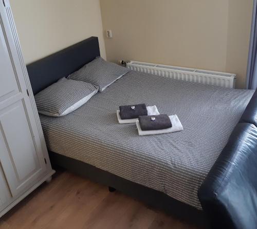 a bedroom with a bed with towels on it at Logement 'De witte klok' in Oude Bildtzijl