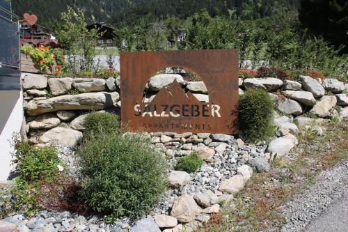 a sign for aalesider sign in a garden at Salzgeber Appartements in Sankt Gallenkirch