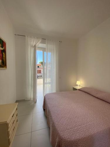 a bedroom with a bed and a sliding glass door at villetta sul mare Rachele in Marina di Campo