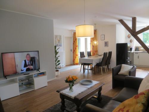 a living room with a tv and a table at Ferienwohnungen Grafenfelder Hof in Gerolstein