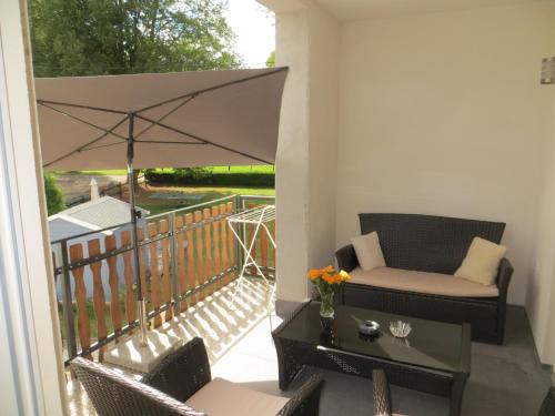 a balcony with a patio furniture and an umbrella at Ferienwohnungen Grafenfelder Hof in Gerolstein