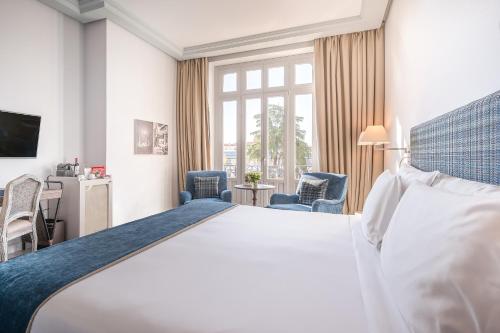 a hotel room with a large bed and a window at URSO Hotel & Spa, a Small Luxury Hotel of the World in Madrid