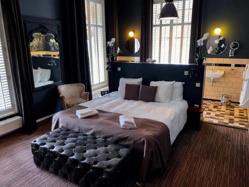 sypialnia z dużym łóżkiem z ławką w obiekcie Hotel Nijver w mieście Geldrop