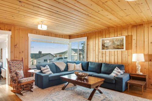 a living room with a blue couch and a table at Madrona Beach House in Madrona Beach