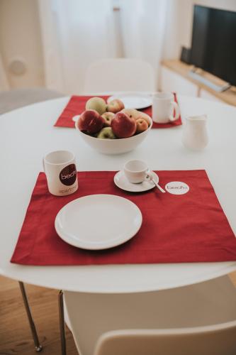 a red tray with a bowl of fruit and two cups at Bed's Apartments in Soave