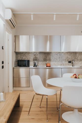 a kitchen with a white table and chairs in a room at Bed's Apartments in Soave