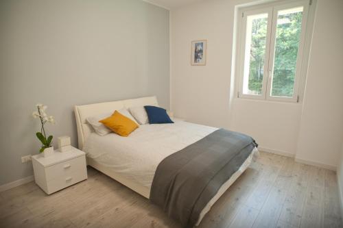 a white bedroom with a bed and a window at Veronese 4 in Trieste