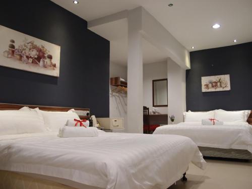 2 Betten in einem Schlafzimmer mit schwarzen Wänden in der Unterkunft One Avenue Hotel, Balakong in Seri Kembangan