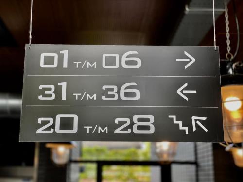 a sign that is hanging from a ceiling at Hotel Nijver in Geldrop