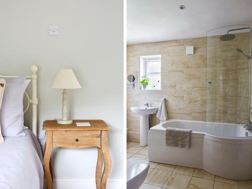 a bedroom with a bed and a tub and a sink at Lilly Cottage in Lydney
