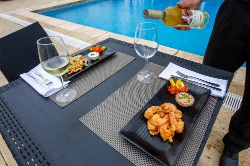 a table with two plates of food and glasses of wine at MS Vila Nova in Ponta Delgada