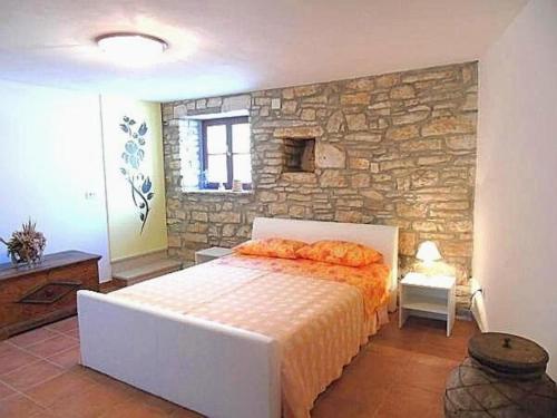 a bedroom with a bed and a stone wall at Villa Rustica in Buje