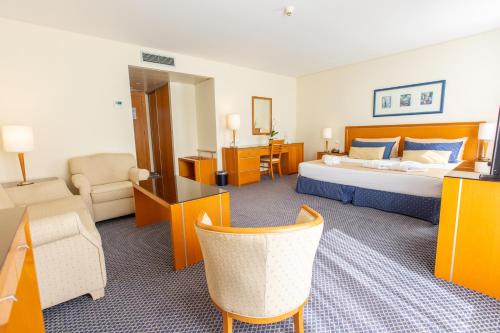 a hotel room with a bed and a living room at MS Vila Nova in Ponta Delgada