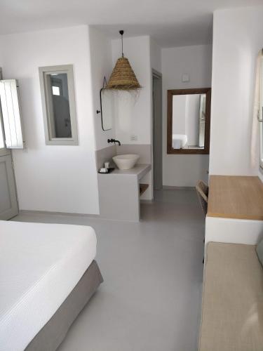 a white bathroom with a bed and a sink at Psathaki in Kimolos