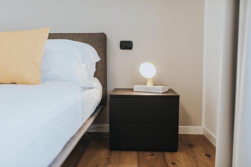 a bed with a night stand with a lamp on it at Bed's Apartments in Soave