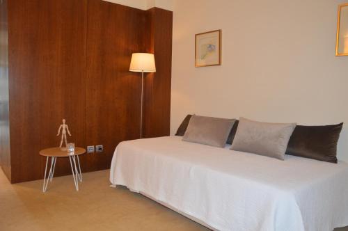 a bedroom with a bed with a table and a lamp at Santana Hotel & SPA in Vila do Conde