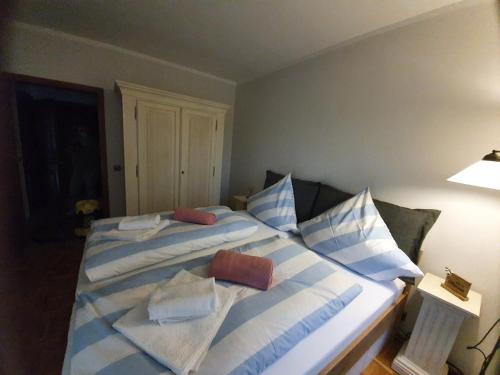 una camera da letto con un grande letto con cuscini blu e bianchi di Pension Petersen a Bergen auf Rügen