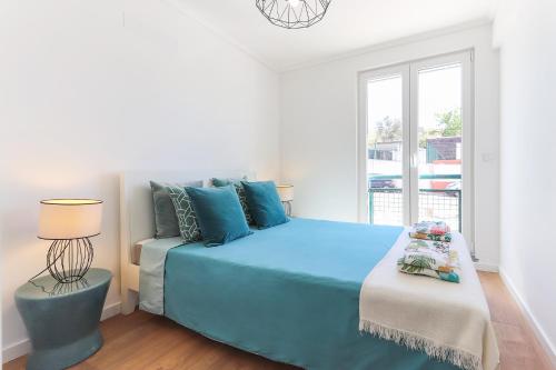 a bedroom with a blue bed and a window at Cosy Guesthouse - Sónias Houses in Lisbon
