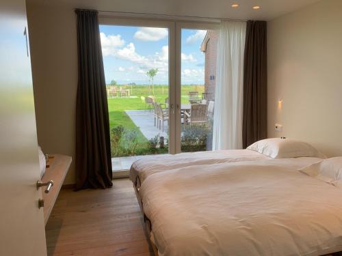 een slaapkamer met een groot bed en een groot raam bij In 't Groen in Watou