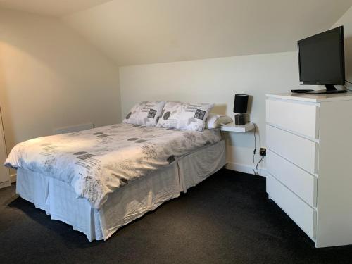 - une chambre avec un lit et une commode avec une télévision dans l'établissement Tron place, à Largs