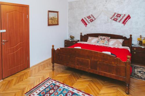 a bedroom with a bed with a red blanket at Casa Vinco Vici in Turda