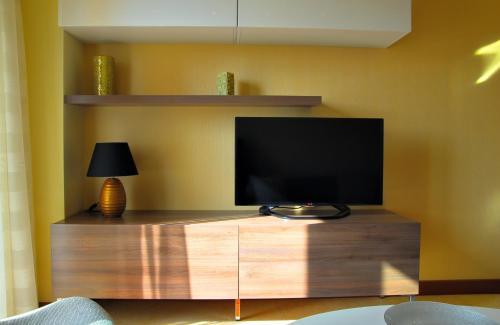 a flat screen tv sitting on top of a wooden entertainment center at Apartments Athos in Podgorica