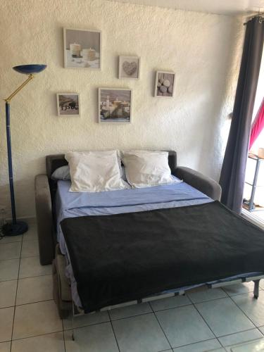 - une chambre avec un lit et une couette noire dans l'établissement Studio 150m de la mer, à Argelès-sur-Mer