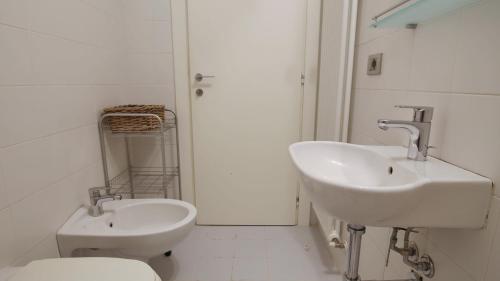 a white bathroom with a sink and a toilet at Italianway - Torno in Torno
