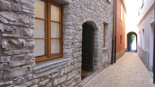 an alley with a window in a stone building at Italianway - Torno in Torno