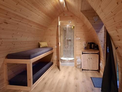 een kleine kamer met een douche in een houten cabine bij Bwlcheinion Sea View Glamping in Machynlleth