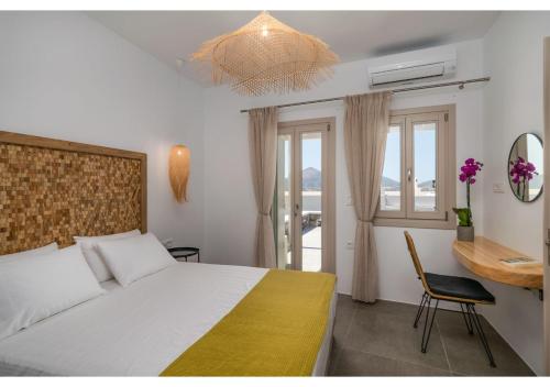a bedroom with a bed and a chair and a window at Pasithea Deluxe in Tripiti