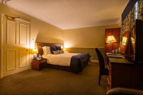 a hotel room with a bed and a desk at The White Hart Hotel, Boston, Lincolnshire - The Coaching Inn Group in Boston
