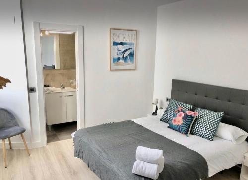 1 dormitorio con 1 cama grande y baño en Apartamento Vive Zaragoza II, en Zaragoza